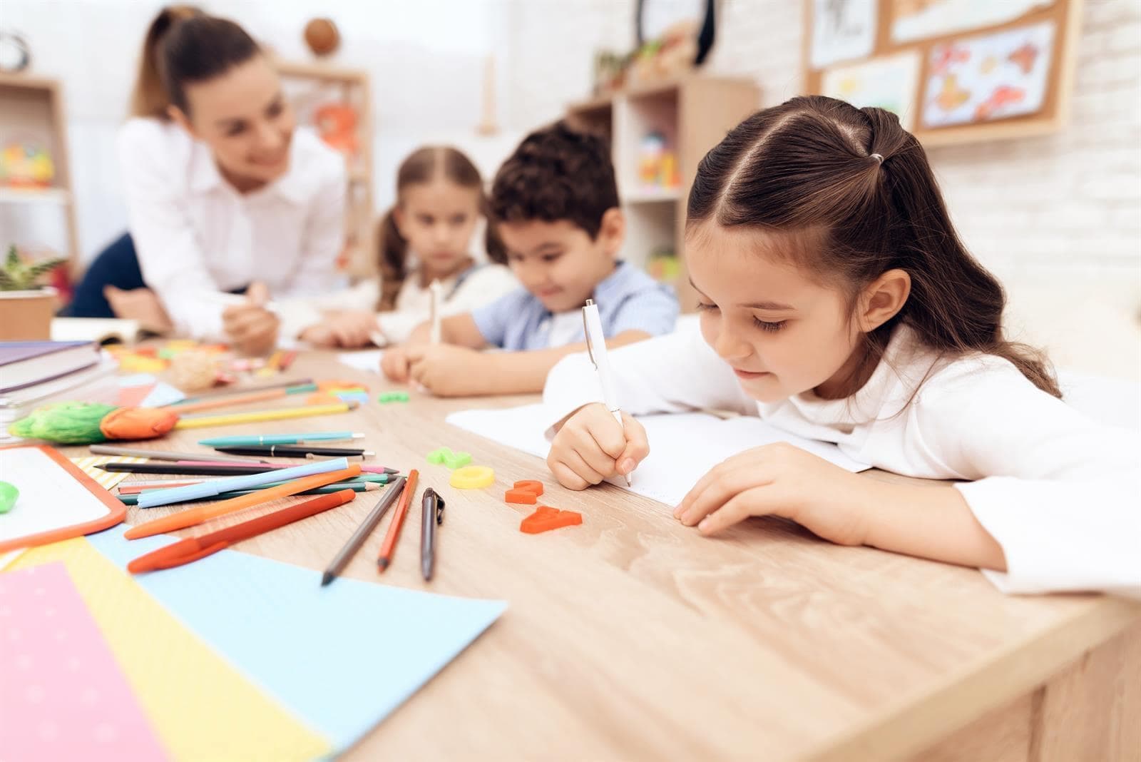 Niñas y niños coloreando en clase