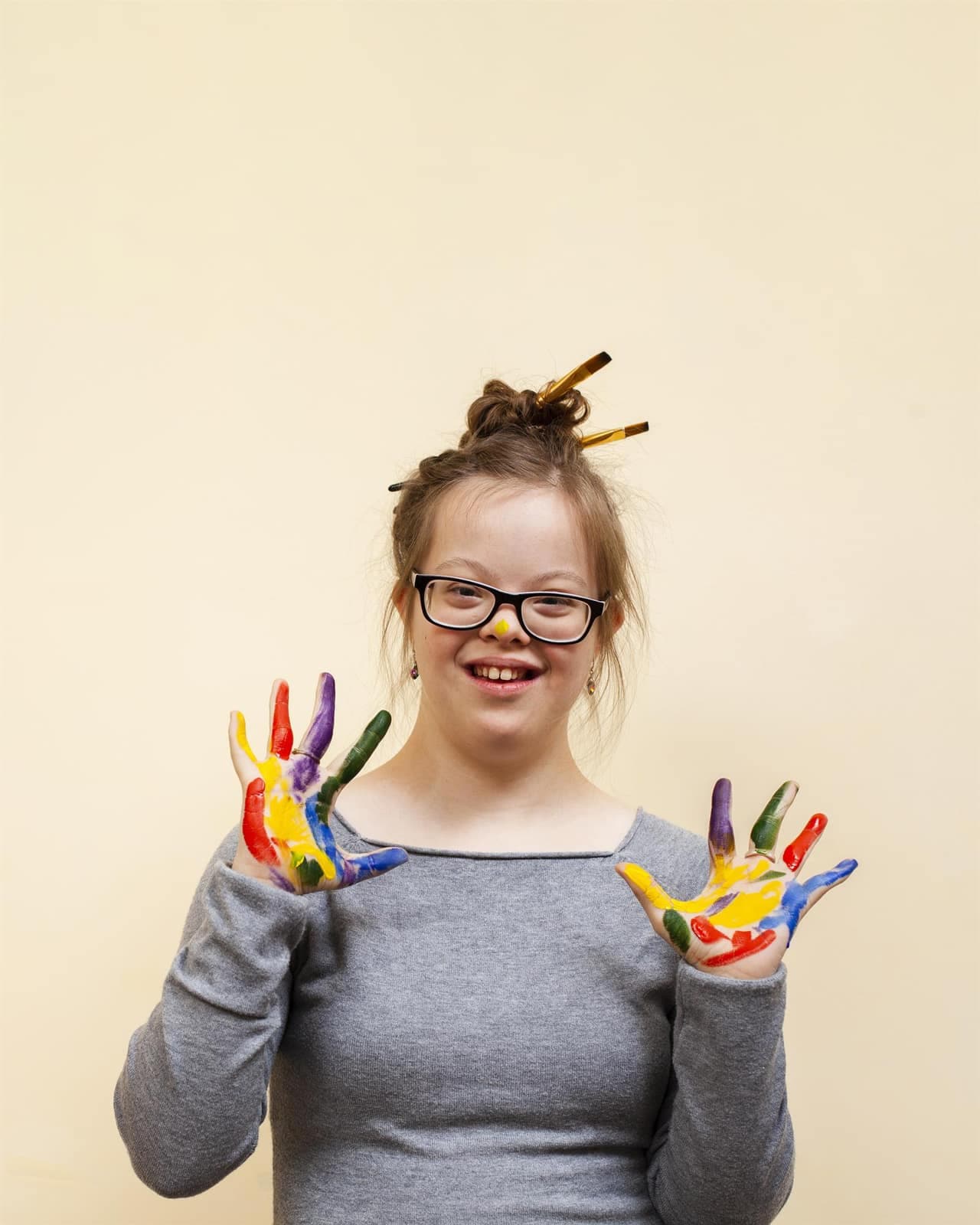 Niña con las manos pintadas de colores