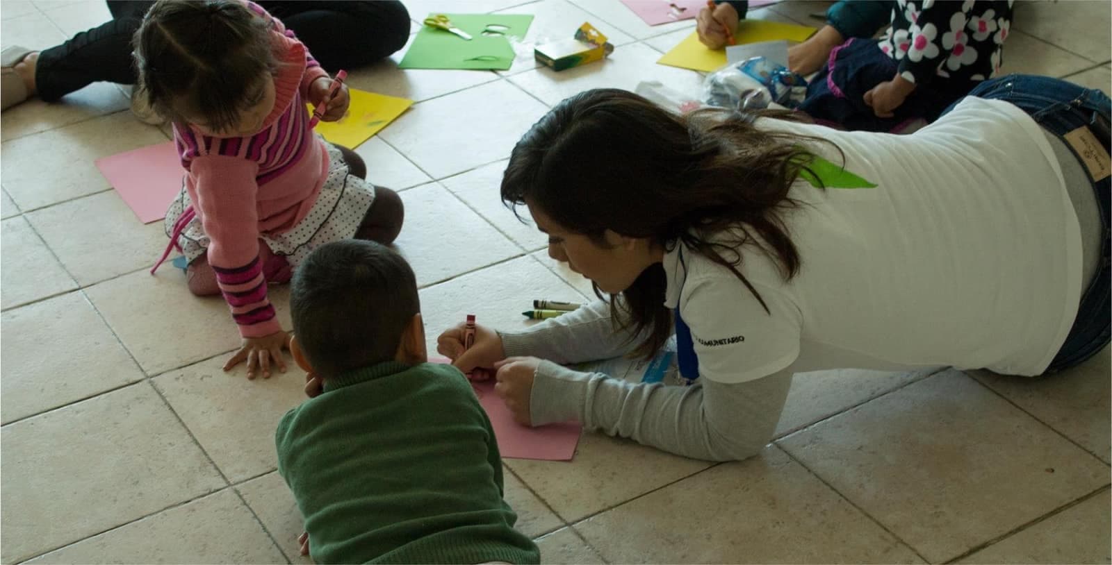 Niñas y niños dibujando en el piso
